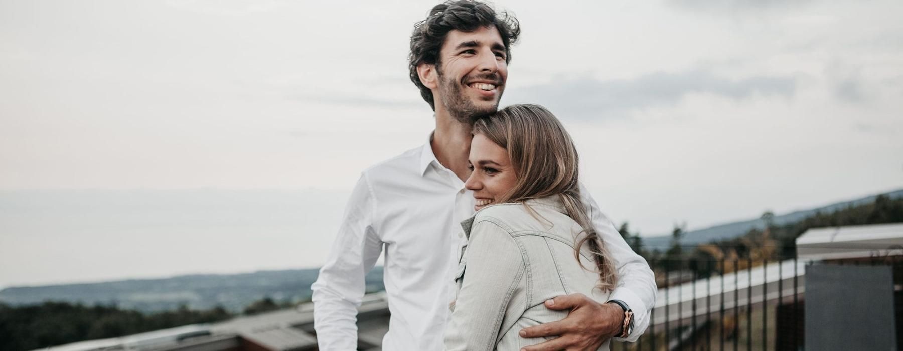 a man and woman hugging on rooftop terrace