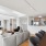 Modern open-concept living space featuring a cozy gray sectional, sleek kitchen with stainless steel appliances, and a stylish dining area with a wooden table.