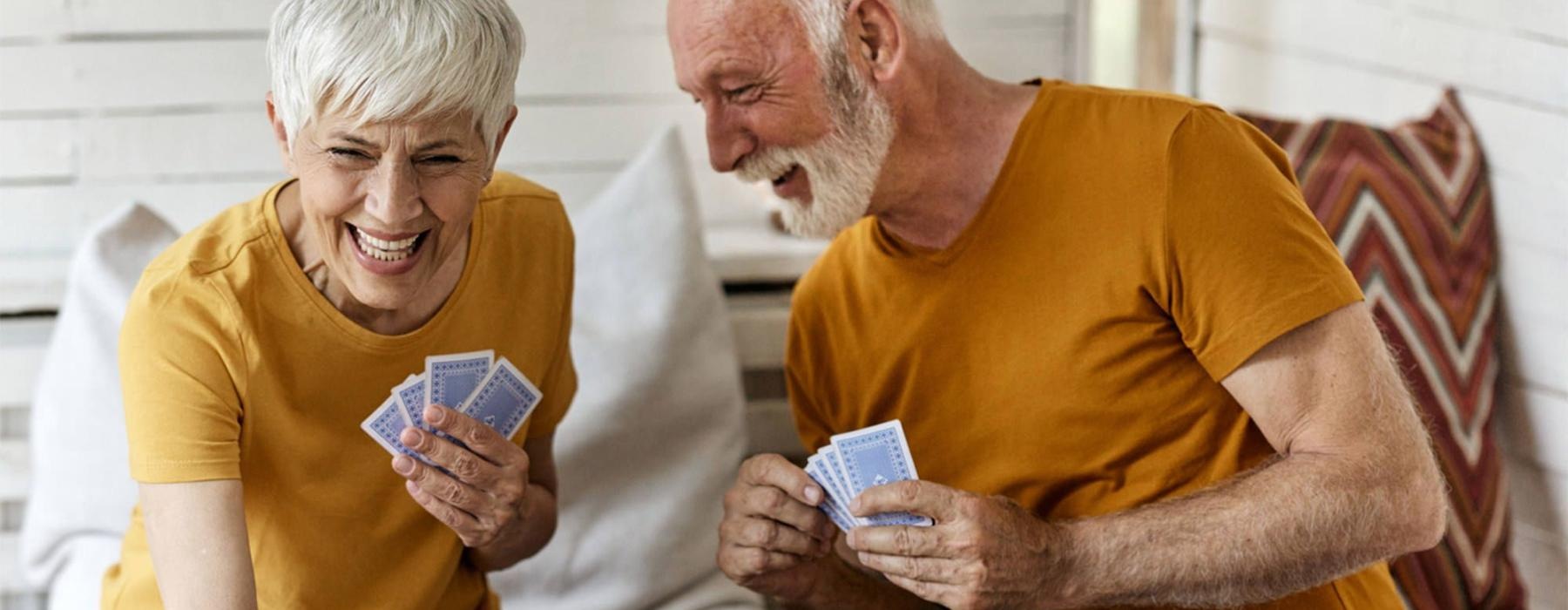 a man and woman sitting at a table playing cards